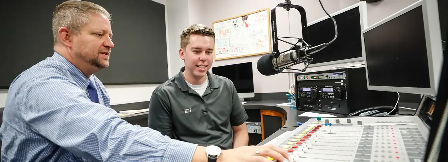 体育菠菜大平台 Student working with Professor in the campus radio station